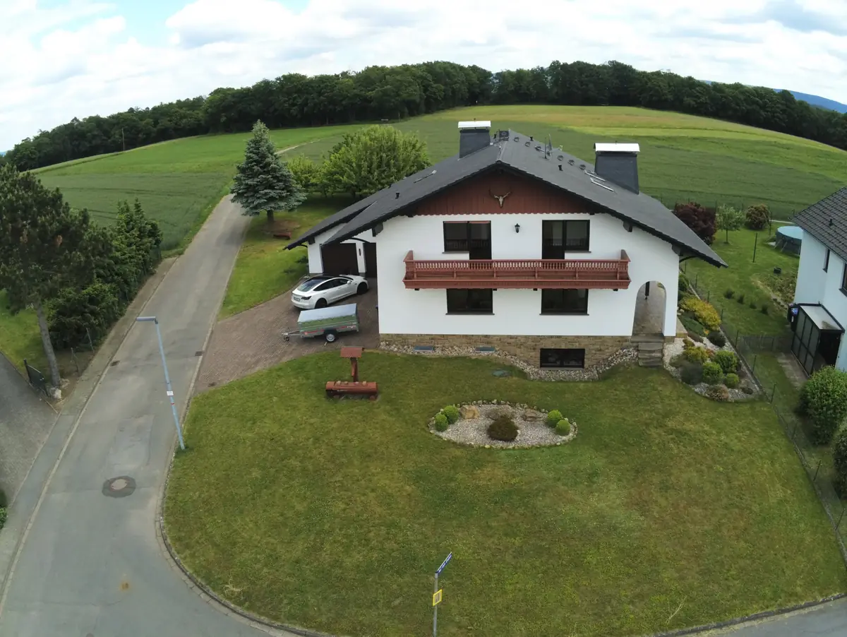 Luftaufnahme des Ferienhauses Werra-Ausblick mit Garten und weitem Blick über Felder und Wälder